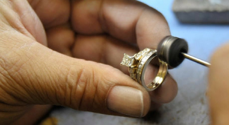 Hand professionally cleaning a gold ring