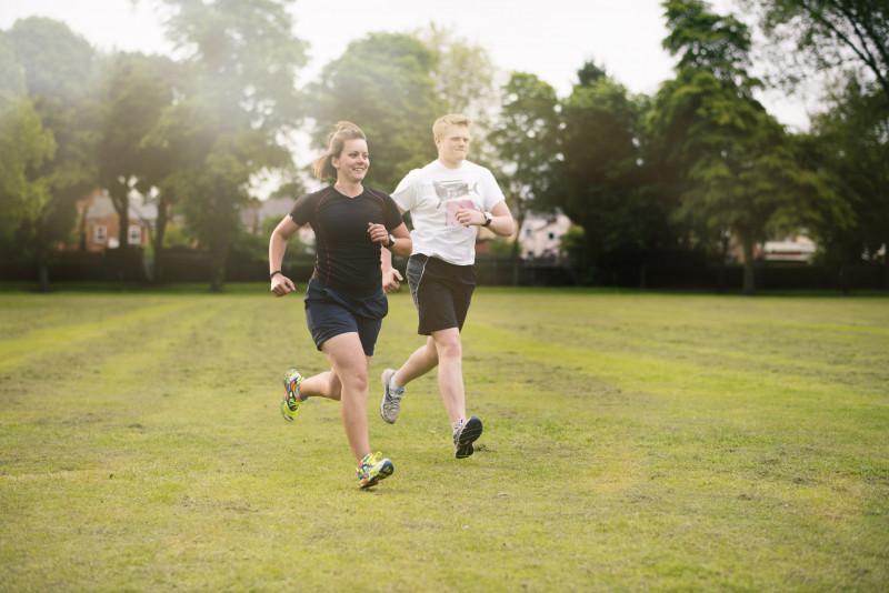 Man and woman running in a green park