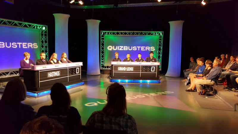 Behind the scenes of Quizbusters TV show recording. 2 panels facing audience members