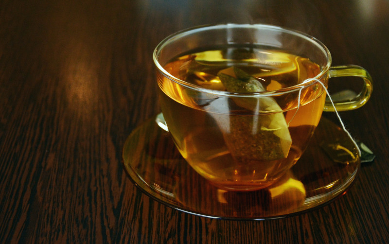 Green tea in a glass mug, on a wooden table