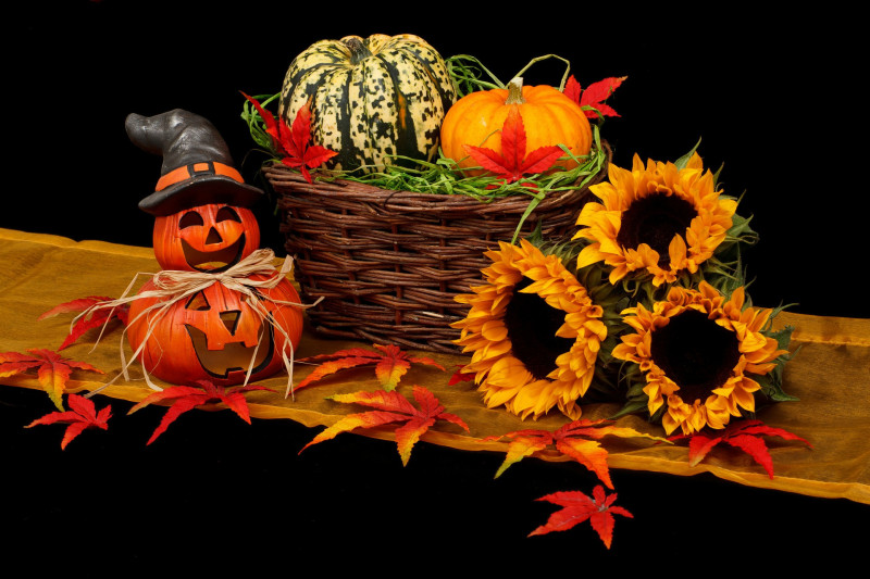 Halloween decorations of carved pumpkins, sunflowers, autumn leaves and a basket