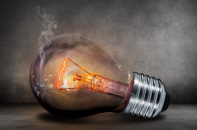 Close up of light bulb lit up with cracked glass