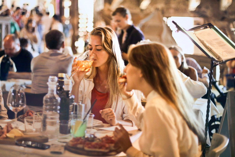 Two ladies dining at a busy restaurant