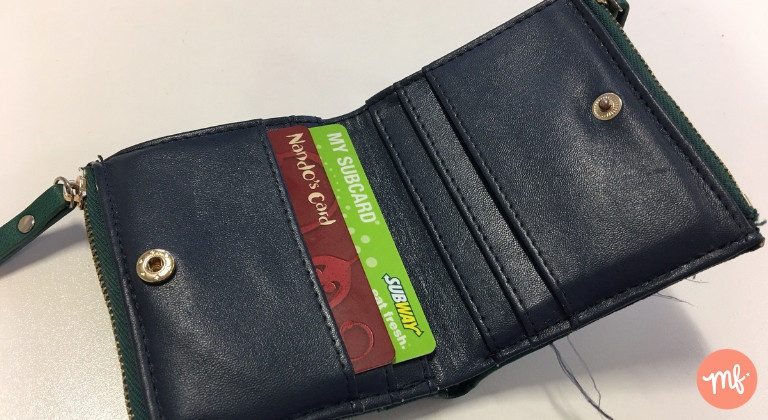 Green purse with Nandos Reward Card and My Subway card inside