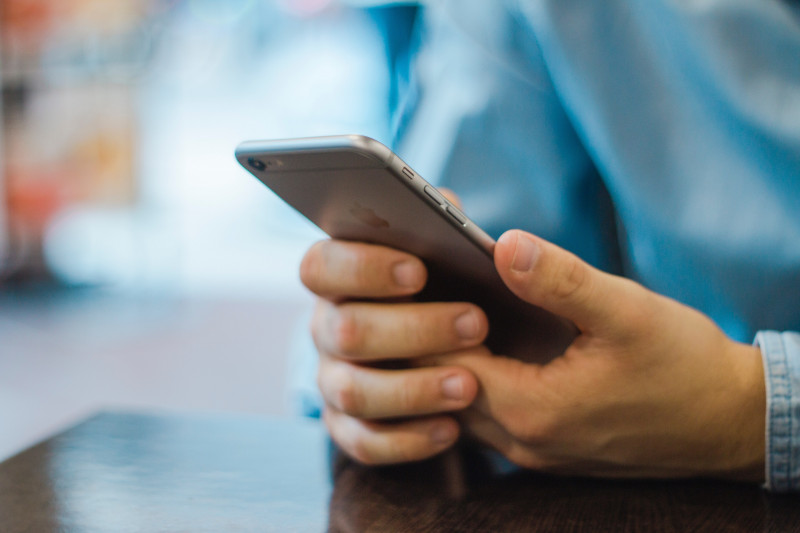 Close up of hand holding a silver iPhone