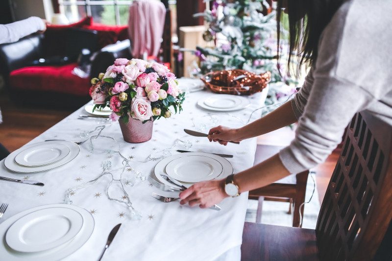 Woman setting up table for Christmas dinner