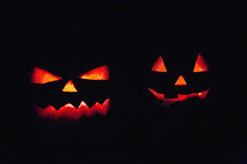 Silhouette of two lit up Halloween pumpkins