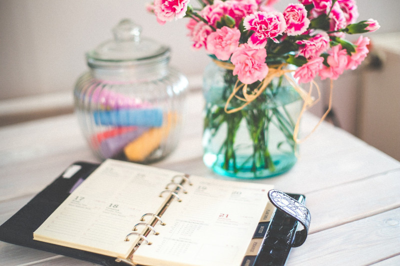 Organiser on a white table with a bunch of flowers