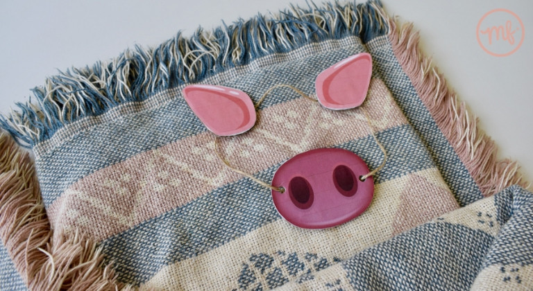Cardboard pig snout and ears laid on a blanket