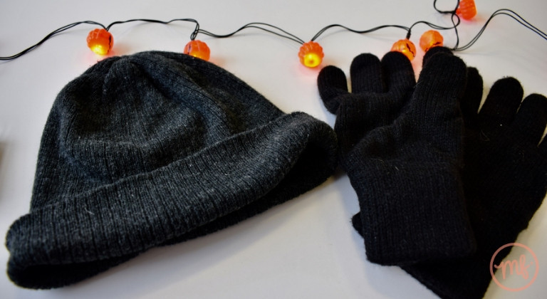 Black hat and black gloves on a white table