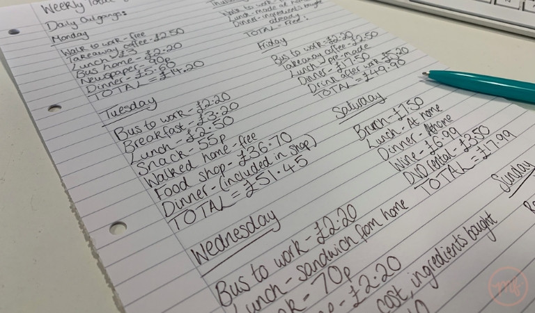 List of daily outgoings with green pen resting on lined paper