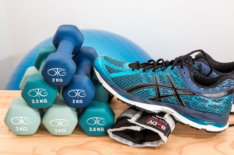 Pair of blue trainers resting on a set of dumbells
