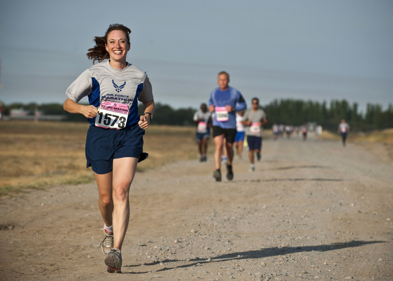 Woman running on brown road during day time